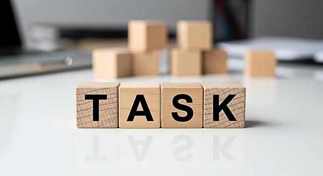 Wooden blocks spelling out TASK on a white desk symbolizing project management and workload conveying a sense of organization and focus in a modern office environment emphasizing productivity photo