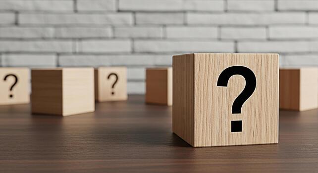 Wooden blocks displaying question marks on a dark wooden surface against a white brick wall symbolizing uncertainty and the need for answers in a business or educational setting fostering curiosity photo