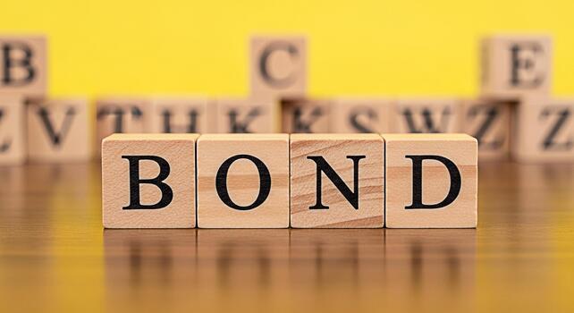 Wooden blocks spelling BOND on a shiny surface against a yellow background symbolizing financial security investment and the concept of strong connections and commitment with a focus on stability and photo