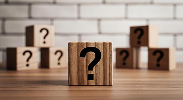 Wooden blocks displaying question marks on a wooden table against a white brick wall symbolizing uncertainty inquiry and the search for answers in a conceptual and thoughtprovoking composition photo