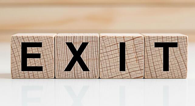 Wooden blocks spelling EXIT on a white surface symbolizing a strategic departure or a clear pathway to success in a challenging business environment evoking a sense of resolution and new beginnings photo