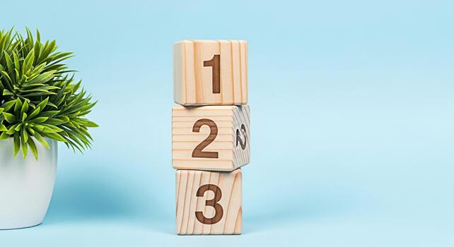 Wooden number blocks stacked in a studio setting with a green plant showcasing learning and development in a playful and educational environment on a light blue background symbolizing growth photo