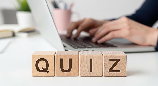 Person taking an online quiz on a laptop in a bright office setting emphasizing education and knowledge assessment with wooden blocks spelling QUIZ in the foreground creating a focused and engaging at photo