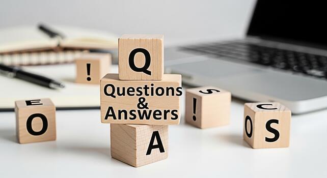 Wooden blocks displaying Questions Answers in a bright office setting symbolizing knowledge and problemsolving with a laptop and notepad in the background creating a learning and informative atmospher photo