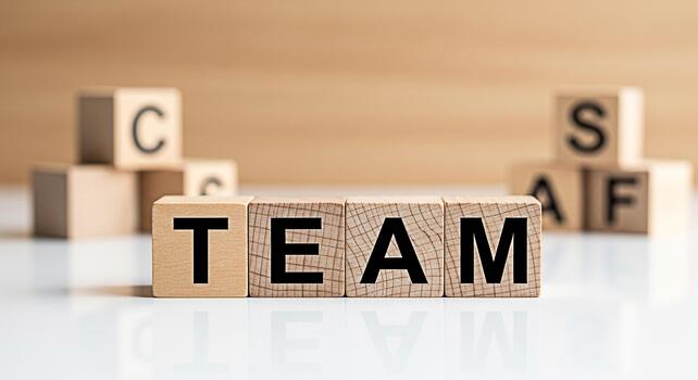 Wooden blocks spelling TEAM on a reflective surface symbolizing collaboration and unity in a bright minimalist office environment fostering a sense of teamwork and shared success photo