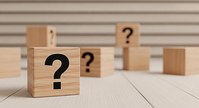 Wooden cubes displaying question marks on a white wooden surface symbolizing uncertainty and the search for answers in a minimalist and contemplative setting creating a sense of curiosity and inquiry photo
