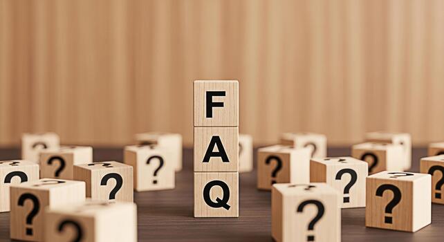 Wooden blocks spelling FAQ standing tall amidst question mark blocks on a wooden surface representing frequently asked questions and seeking answers in a simple clear and accessible manner photo