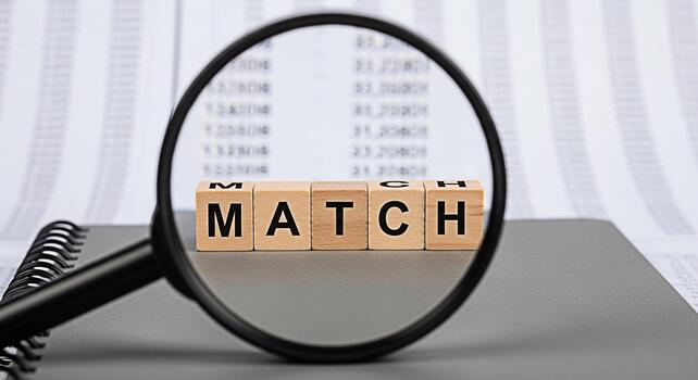 Magnifying glass focusing on wooden blocks spelling MATCH on a notebook symbolizing precision and accuracy in data analysis creating a mood of attention to detail and strategic alignment photo