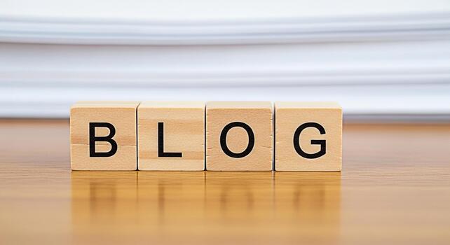 Wooden blocks spelling BLOG on a wooden table with a stack of paper in the background representing the concept of blogging content creation and online communication in a simple and clean setting photo