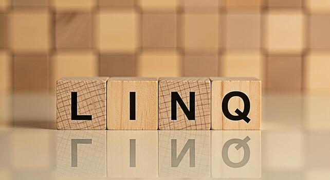 Wooden blocks spelling LINQ on a reflective surface in a studio setting symbolizing connection data querying and powerful programming capabilities for software development and database management syst photo
