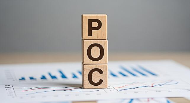 Wooden blocks displaying POC on a desk with financial charts representing Proof of Concept in a business setting conveying a message of validation and strategic planning for project success photo