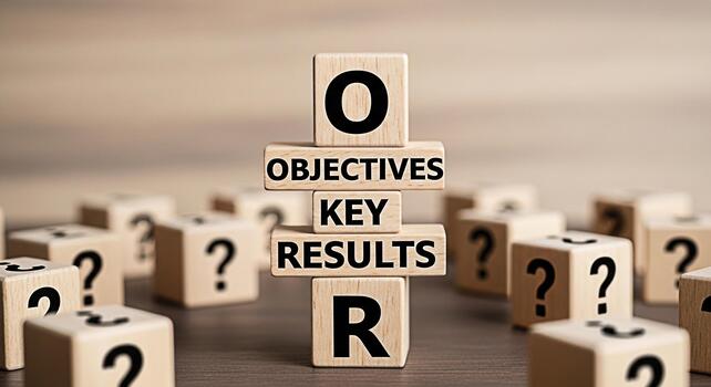 Wooden blocks spelling out OKR Objectives Key Results in a business setting surrounded by question mark blocks representing goal setting strategic planning and performance measurement with a focus on photo