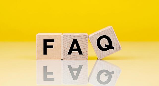 Wooden blocks displaying FAQ on a reflective surface against a vibrant yellow background representing frequently asked questions and providing helpful information with a clear and concise approach photo