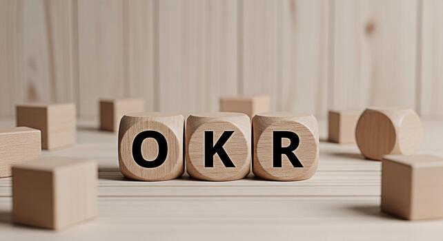Wooden blocks displaying OKR acronym on a bright wooden surface representing Objectives and Key Results a strategic framework for defining and tracking objectives fostering focus and alignment photo