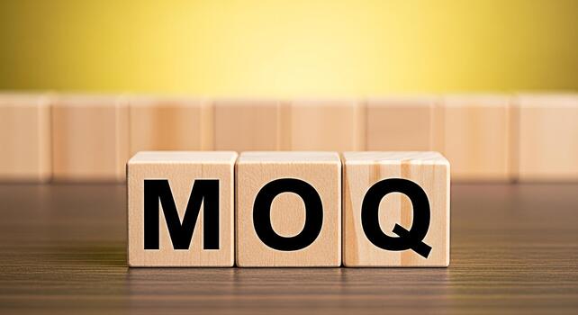 Wooden blocks displaying MOQ on a wooden surface against a blurred yellow background representing Minimum Order Quantity in a business and trade context conveying clarity and importance photo