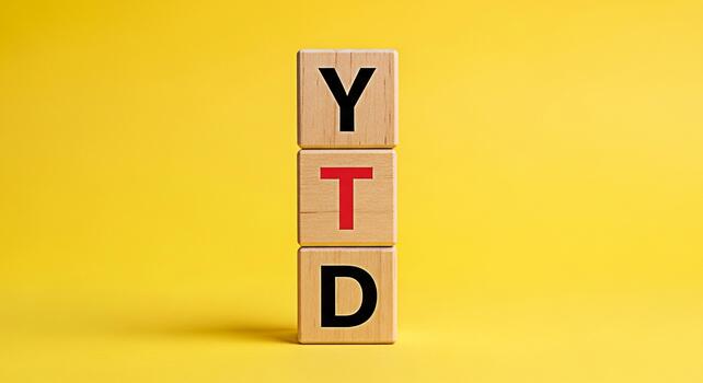 Wooden blocks displaying YTD on a vibrant yellow background representing yeartodate financial performance and progress symbolizing business growth and achievement in a visually appealing and concise m photo