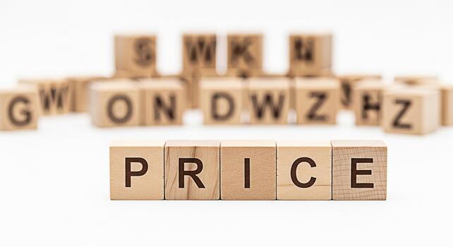 Wooden blocks spelling out PRICE on a white surface surrounded by other letter blocks representing the concept of value cost and financial considerations in a clean minimalist setting photo