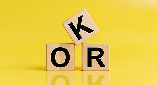 Wooden blocks spelling OK or on a bright yellow background representing decision making and choices conveying a sense of options and possibilities in a simple minimalist style photo