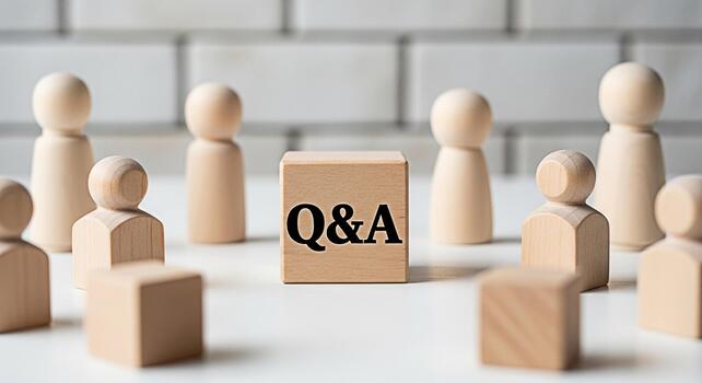 Wooden figures gather around a QA block on a white table symbolizing a collaborative discussion and knowledge sharing in a bright minimalist setting fostering a sense of community and problemsolving photo