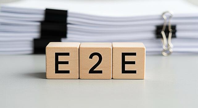 Wooden blocks spelling E2E on a desk with a stack of papers symbolizing endtoend process representing a complete and efficient workflow in a business or project management setting conveying clarity an photo