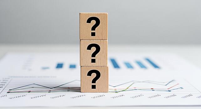 Stacked wooden blocks displaying question marks on a financial chart representing uncertainty and analysis in a business setting creating a mood of inquiry and the need for strategic decisionmaking photo