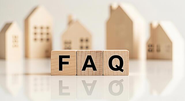 Wooden blocks displaying FAQ in a bright minimalist setting with blurred house models representing frequently asked questions about real estate and creating a sense of clarity and information photo