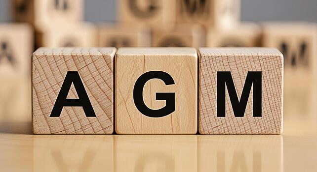 Wooden blocks displaying the letters AGM on a wooden surface representing an Annual General Meeting in a corporate setting conveying a sense of formality and importance for shareholders photo