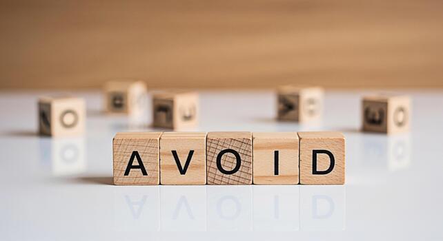 Wooden blocks spelling AVOID on a white surface suggesting prevention and caution in a clean minimalist setting conveying a sense of control and strategic decisionmaking for risk management photo