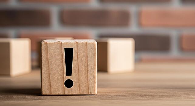Wooden block displaying an exclamation mark on a wooden table against a brick wall symbolizing attention warning and important information in a simple and minimalist design for business and education photo