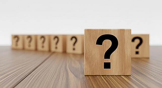 Wooden blocks displaying question marks on a wooden table symbolizing uncertainty and the search for answers in a simple minimalist setting creating a mood of curiosity and inquiry photo