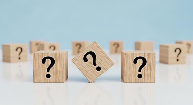 Wooden blocks displaying question marks on a reflective surface symbolizing uncertainty and the need for answers in a bright minimalist setting creating a sense of curiosity and problemsolving photo