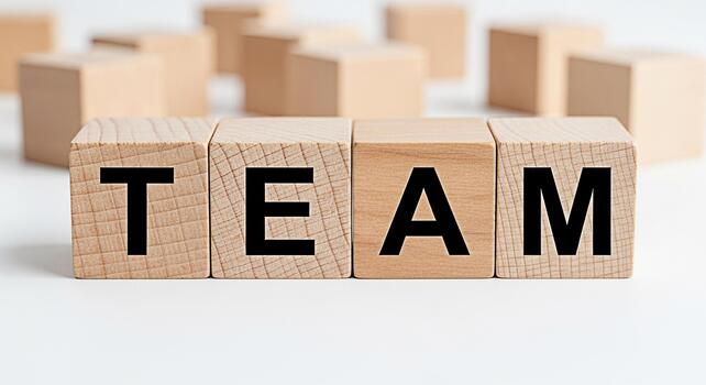 Wooden blocks spelling TEAM on a white surface representing collaboration and unity in a business setting fostering a positive and supportive team environment for achieving common goals promoting team photo
