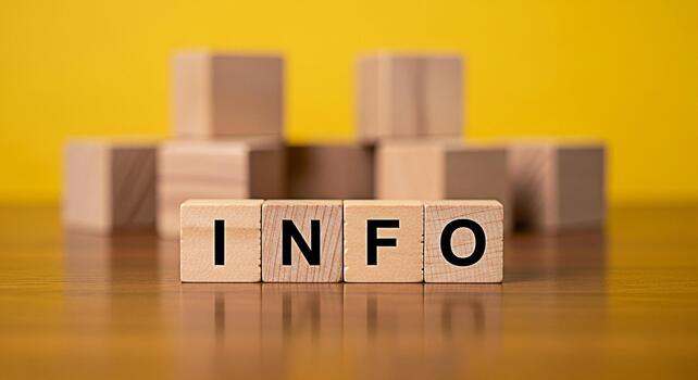 Wooden blocks spelling INFO on a polished wooden surface against a bright yellow background representing information knowledge and the importance of data in a clear and concise way photo