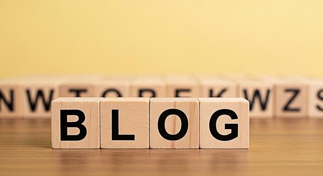 Wooden blocks spelling BLOG on a wooden table against a yellow background representing online content creation and the sharing of ideas in a simple and engaging way perfect for digital marketing photo