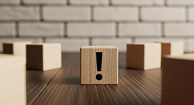 Wooden block displaying an exclamation point on a wooden surface against a brick wall symbolizing urgency attention and the importance of problemsolving in a critical situation photo
