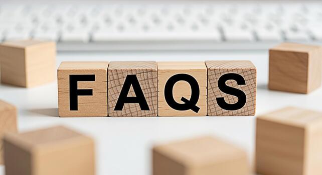 Wooden blocks displaying FAQs on a white table near a keyboard representing frequently asked questions and providing information creating a helpful and informative atmosphere for users seeking answers photo