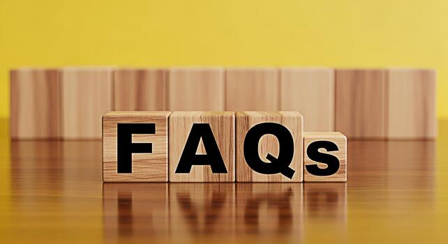 Wooden blocks displaying FAQs on a reflective wooden surface against a bright yellow background representing frequently asked questions and knowledge resources in a clear and concise manner photo