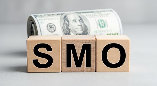 Wooden blocks spelling SMO in a bright studio setting representing social media optimization strategies for business growth and increased revenue with a roll of US currency in the background photo