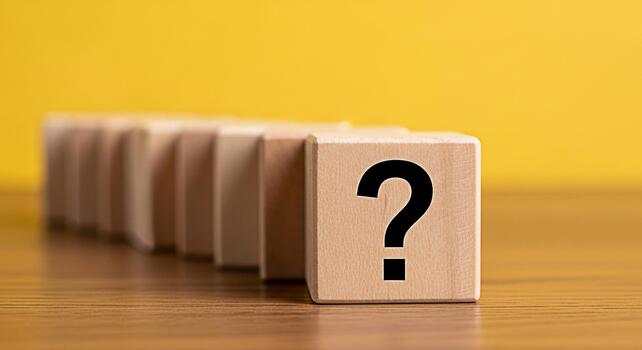 Wooden block displaying a question mark on a wooden surface against a yellow background representing uncertainty inquiry and the search for solutions in problemsolving and decisionmaking processes photo