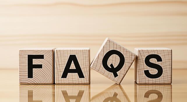 Wooden blocks displaying FAQs on a reflective surface symbolizing readily available information and solutions for customer service and support promoting clarity and accessibility photo