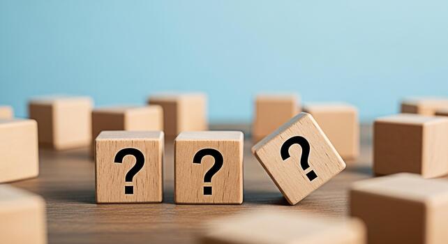 Wooden blocks displaying question marks on a wooden surface symbolizing uncertainty and the search for answers in a learning environment against a blue background fostering curiosity and problemsolvin photo