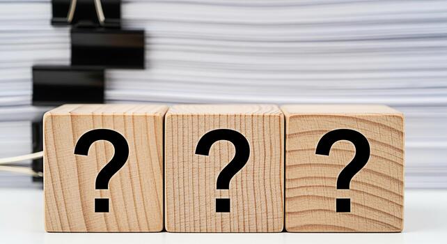 Three wooden blocks displaying question marks in a bright studio setting symbolizing uncertainty and the need for answers amidst a stack of documents creating a sense of inquiry and problemsolving photo