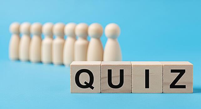 Wooden figures standing behind the word QUIZ spelled out on wooden blocks against a blue background representing a test or challenge and creating a sense of anticipation and curiosity photo