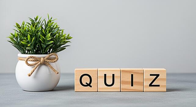Wooden blocks spelling QUIZ next to a potted plant on a gray surface creating a clean and educational atmosphere perfect for online learning and knowledge assessment concepts photo