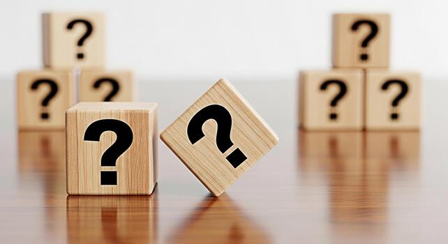 Wooden blocks displaying question marks on a reflective surface symbolizing uncertainty and the need for answers in a complex problemsolving scenario fostering curiosity and critical thinking in a bus photo