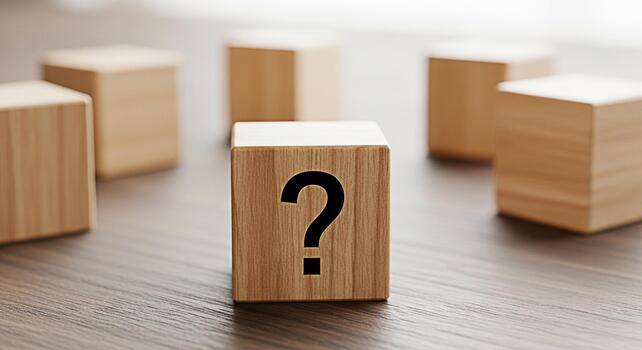 Wooden cube displaying a question mark on a wooden surface surrounded by other cubes representing uncertainty and the need for answers in a minimalist and conceptual setting photo