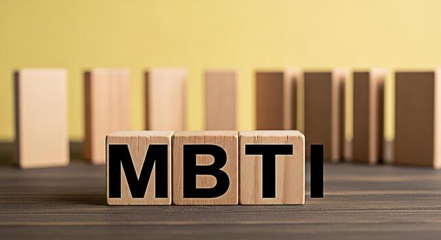 Wooden blocks displaying MBTI on a dark wooden surface with a yellow background representing personality assessment and psychological type theory in a clear and informative manner photo