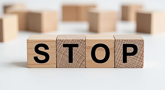 Wooden blocks spelling STOP on a clean white surface creating a powerful message of halt and prevention symbolizing control and the importance of pausing for reflection and decisionmaking photo