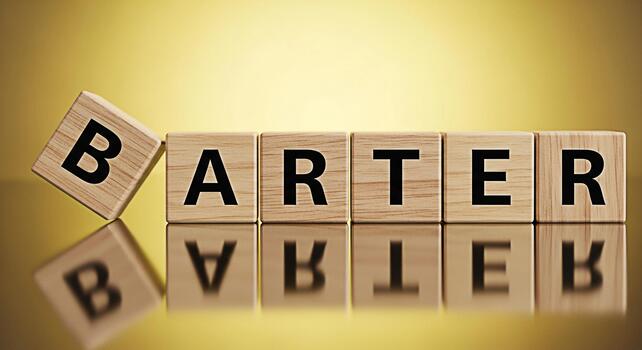 Wooden blocks spelling BARTER on a reflective surface against a golden background representing trade exchange and the concept of bartering in a modern and visually appealing way photo