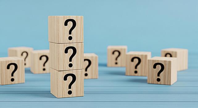 Stacked wooden blocks displaying question marks on a blue wooden surface representing uncertainty and the need for answers in a conceptual and inquisitive setting perfect for educational materials photo